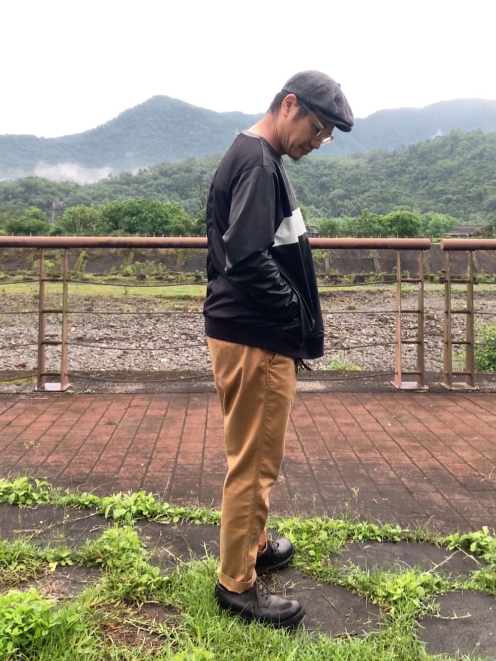 ブラック系のその他トップス、ブラウン系のチノパンツ、ブラック系のブーツを着用したメンズの春コーディネートの4枚目の写真