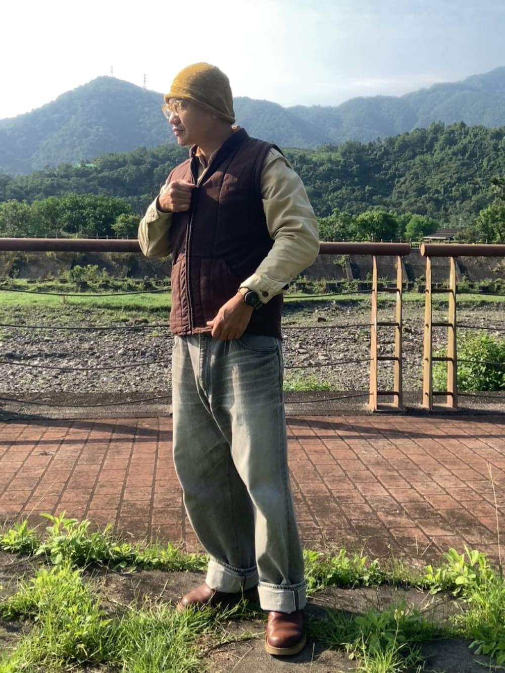 ベージュ系のデニムジャケット、ブラウン系のスリッポン、レッド系のその他アウターを着用したメンズの春コーディネートの4枚目の写真