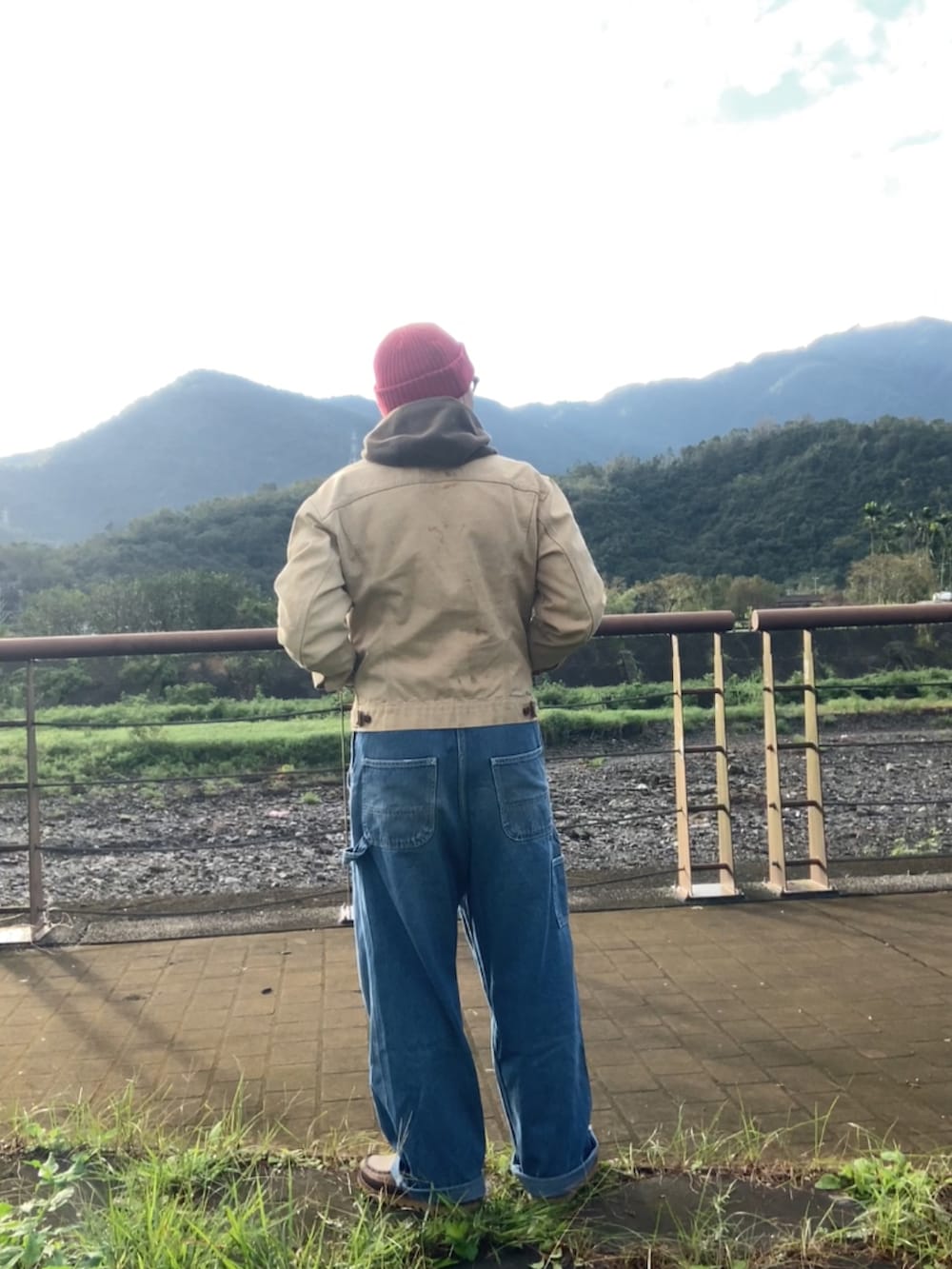 ベージュ系のデニムジャケット、ブルー系のサロペット/オーバーオール、ブラウン系のブーツを着用したメンズの冬コーディネートの3枚目の写真