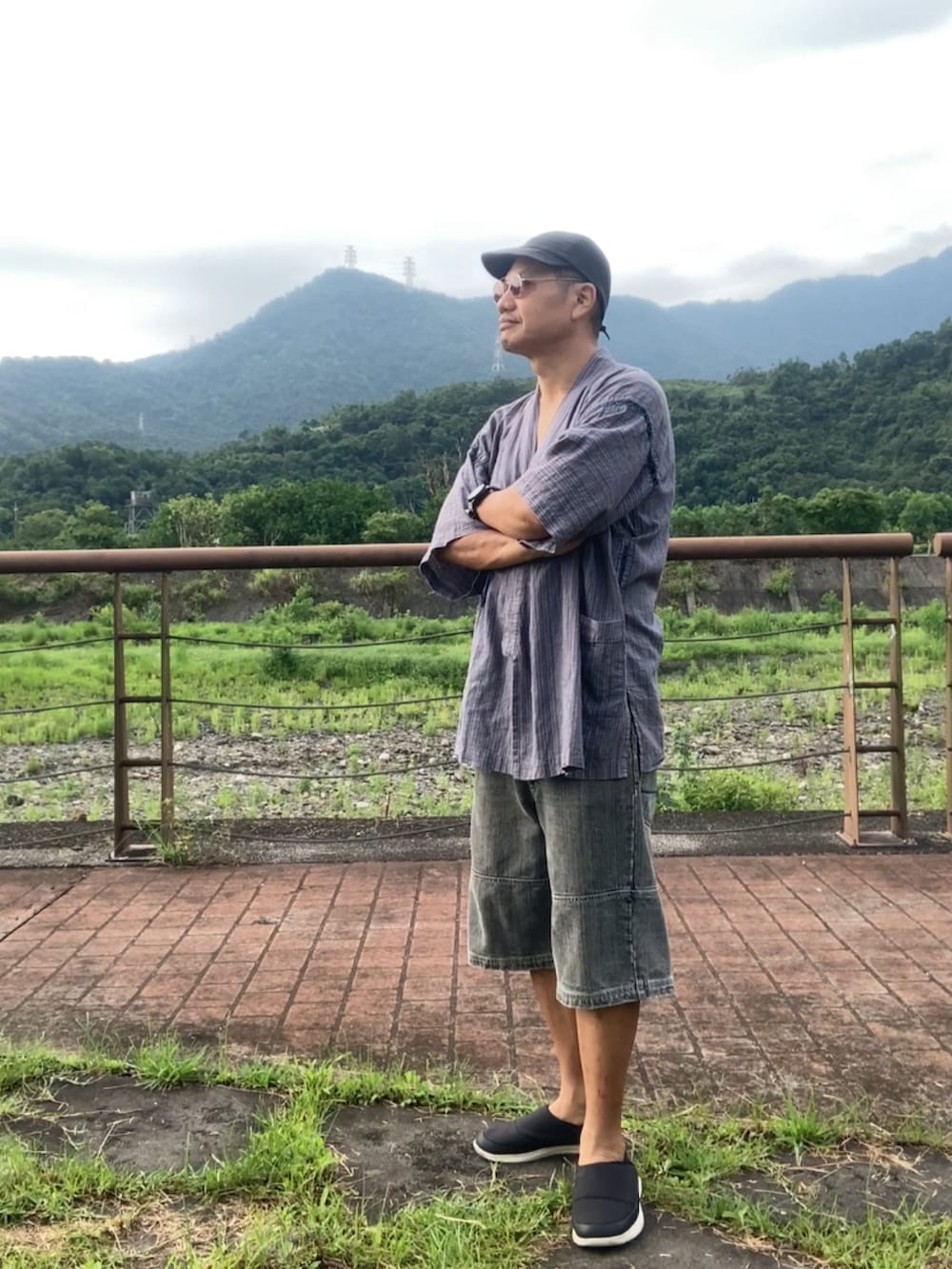 ブラック系のスリッポン、グレー系のその他トップス、グレー系のTシャツ/カットソーを着用したメンズの夏コーディネートの2枚目の写真