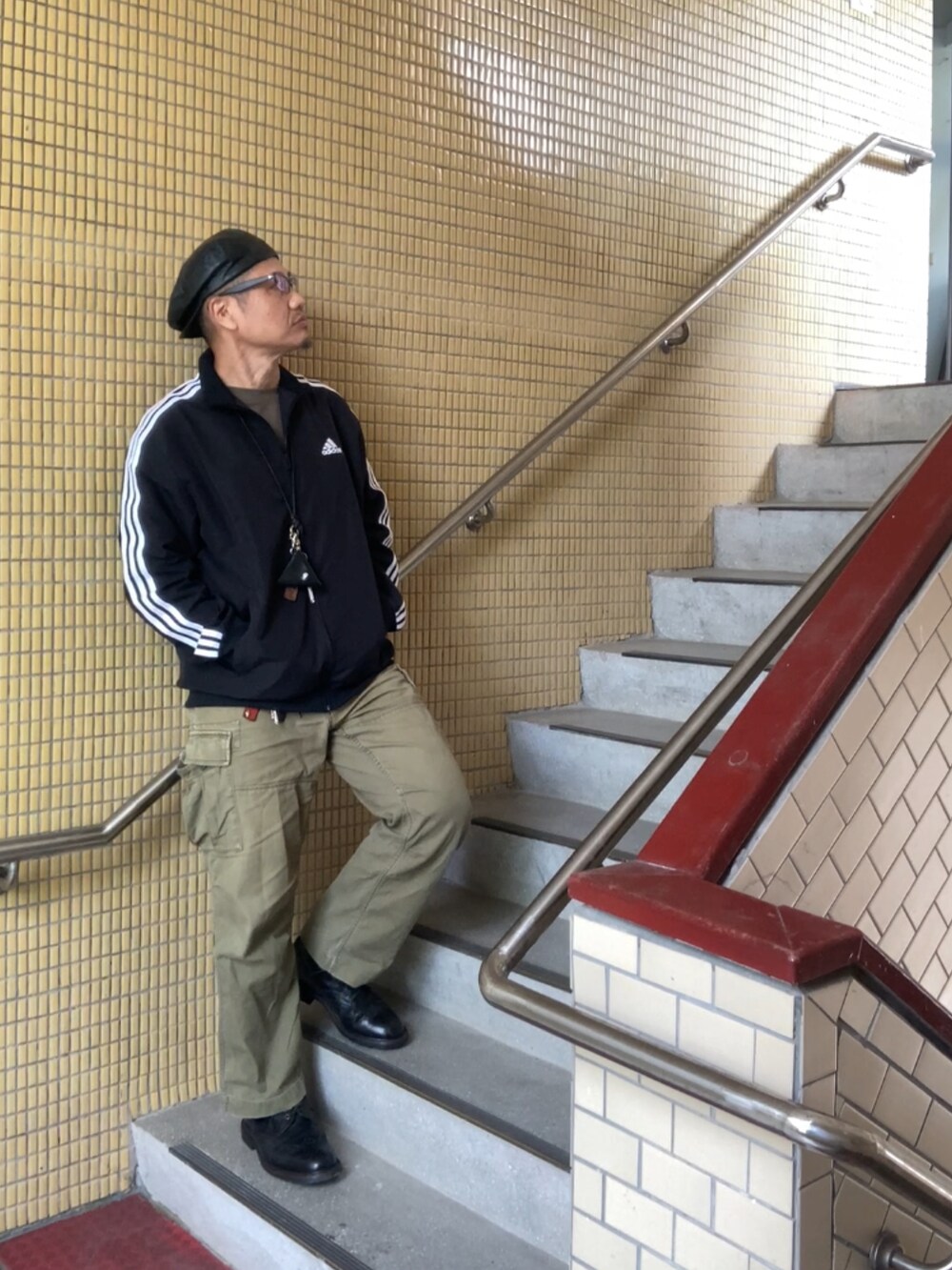 ブラック系のジャージ、グレー系のTシャツ/カットソー、グリーン系のカーゴパンツを着用したメンズの春コーディネートの2枚目の写真