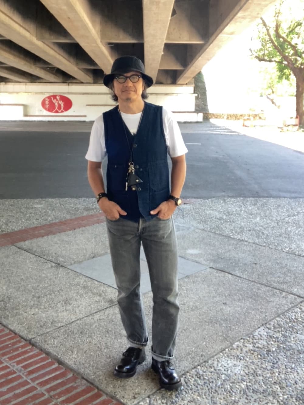 ホワイト系のTシャツ/カットソー、ブルー系のベスト、ブラック系のデニムパンツを着用したメンズの夏コーディネートの2枚目の写真