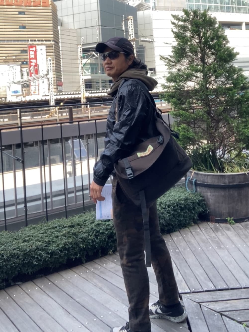 ブラック系のメッセンジャーバッグ、ブラック系のナイロンジャケット、その他のその他パンツを着用したメンズの春コーディネートの2枚目の写真