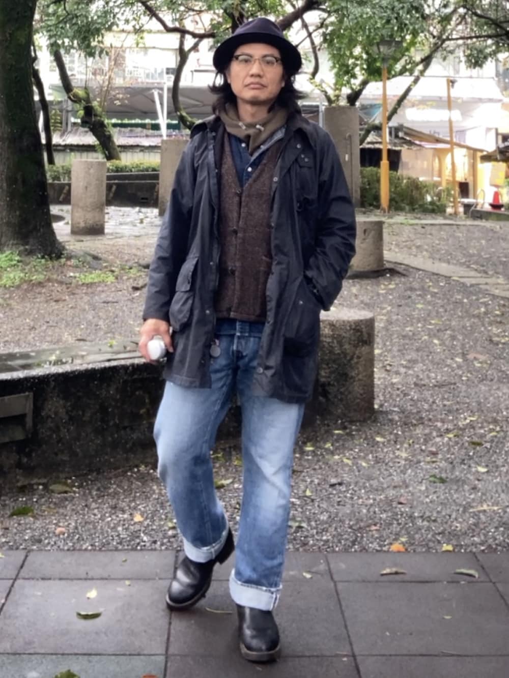 ブルー系のデニムパンツ、ブラック系のブーツ、ブラウン系のベストを着用したメンズの冬コーディネートの3枚目の写真