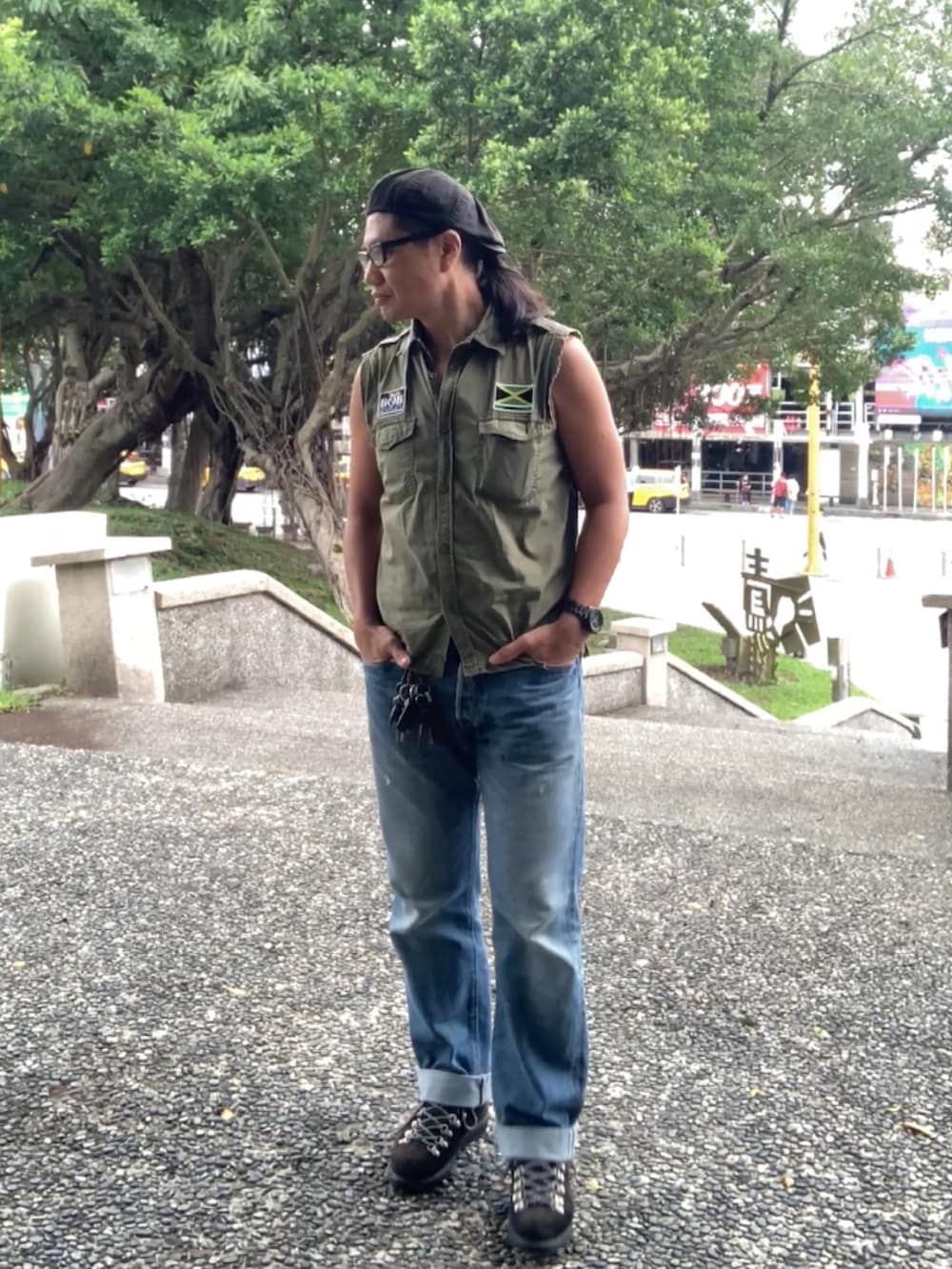 グリーン系のシャツ/ブラウス、ブルー系のデニムパンツ、ブラック系のブーツを着用したメンズの春コーディネートの2枚目の写真