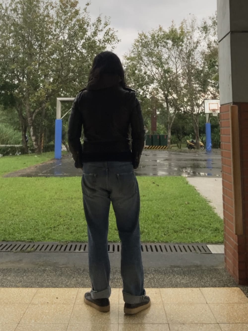 ブラック系のスニーカー、ブルー系のデニムパンツ、ブラック系のミリタリージャケットを着用したメンズの秋コーディネートの2枚目の写真