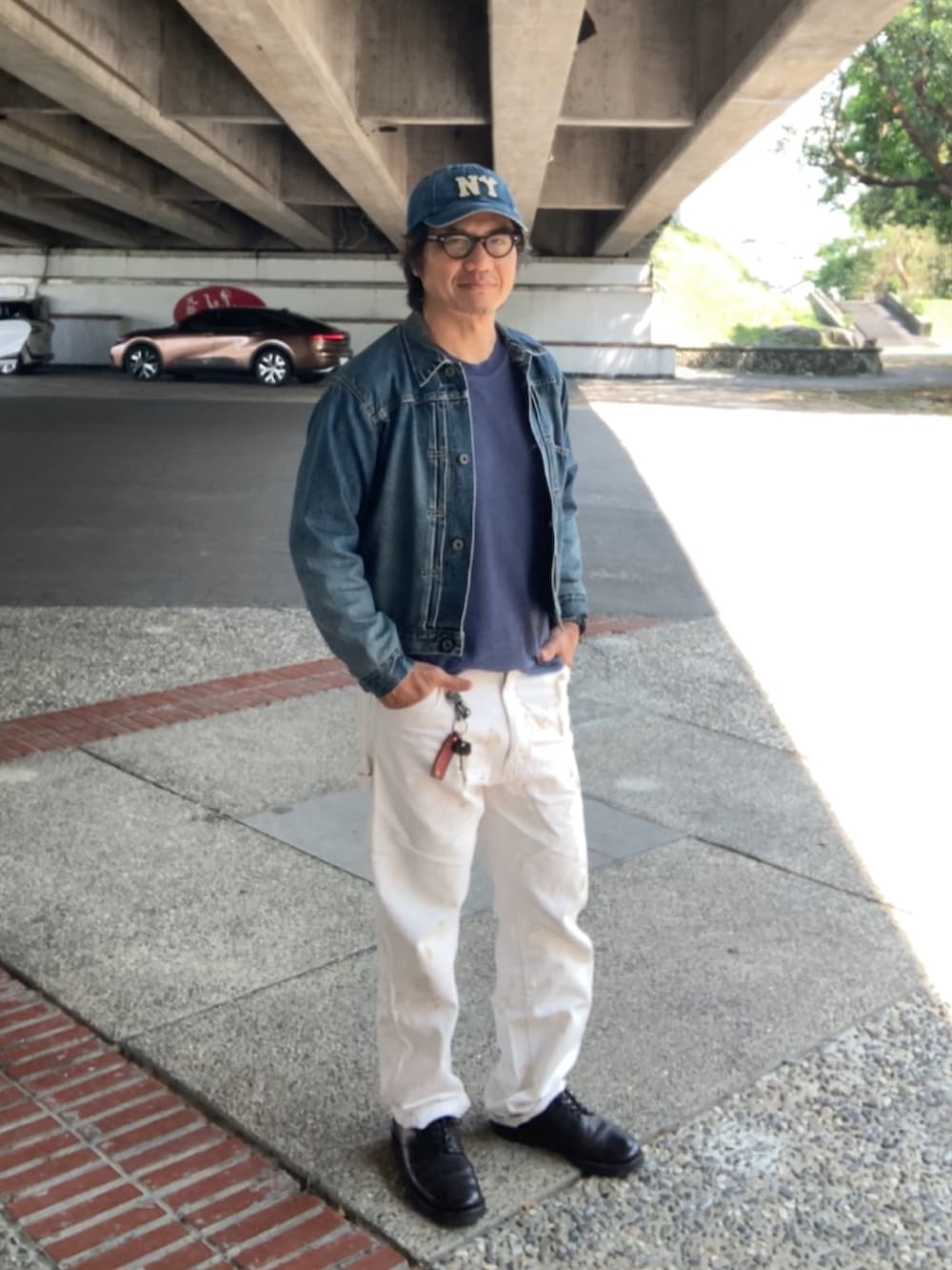 ブラウン系のTシャツ/カットソー、ブルー系のデニムジャケット、ホワイト系のその他パンツを着用したメンズの春コーディネートの2枚目の写真