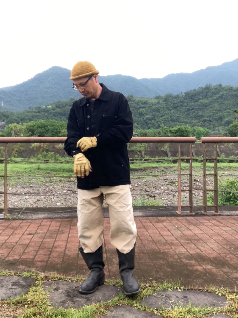 ブラック系のTシャツ/カットソー、ブラウン系のサロペット/オーバーオール、ブラック系のカバーオールを着用したメンズの春コーディネートの4枚目の写真