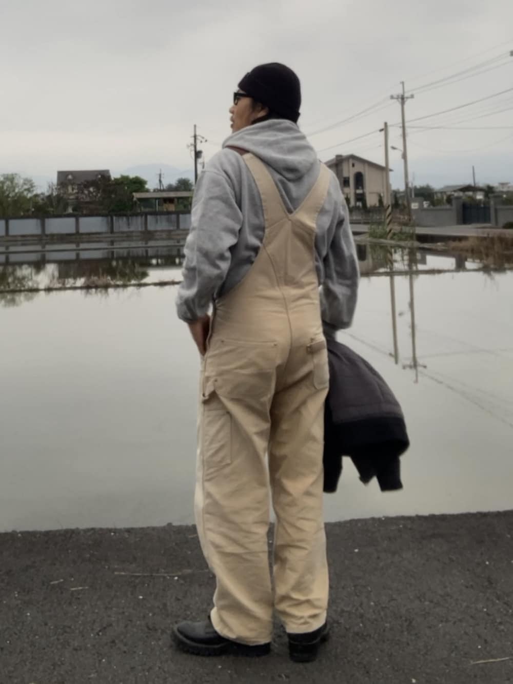 ブラック系のMA-1、ブラウン系のサロペット/オーバーオール、ブラック系のブーツを着用したメンズの冬コーディネートの4枚目の写真