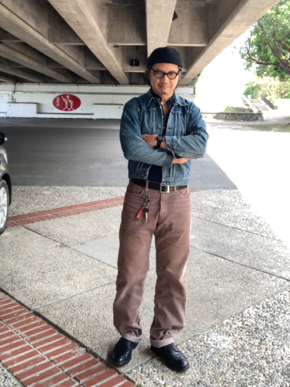 ブラック系のTシャツ/カットソー、ブルー系のデニムジャケット、ブラウン系のその他パンツを着用したメンズの春コーディネートの2枚目の写真