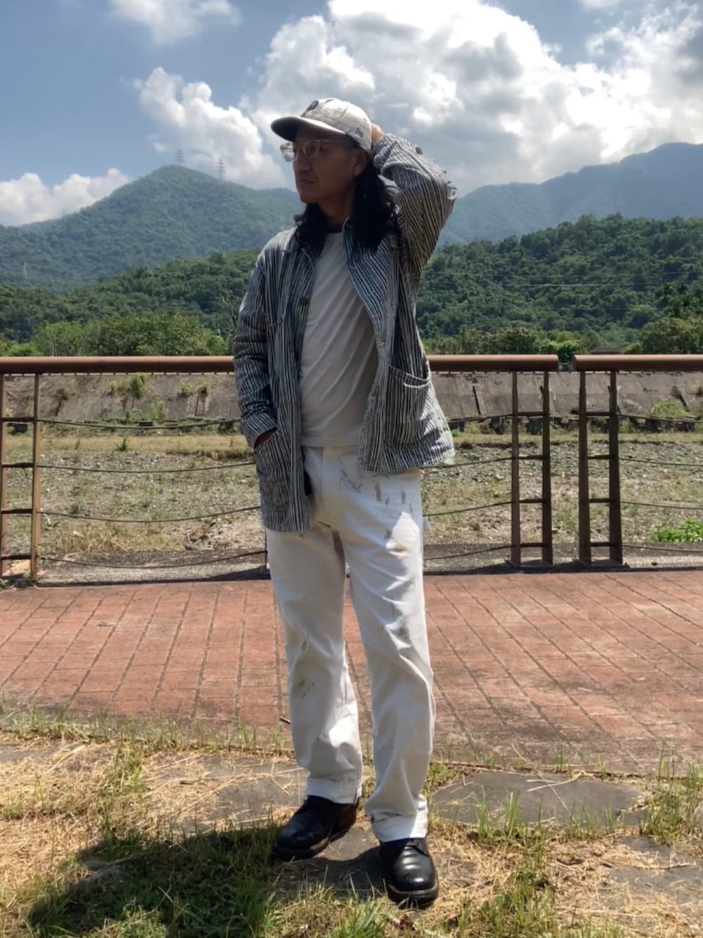 ブラック系のブーツ、ベージュ系のカバーオール、グレー系のTシャツ/カットソーを着用したメンズの夏コーディネートの3枚目の写真