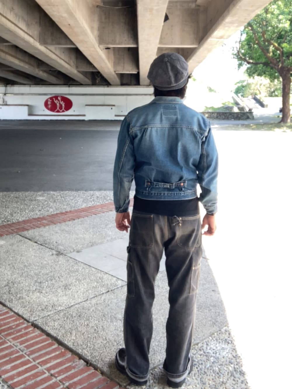 ブルー系のデニムジャケット、ブラック系のデニムパンツ、ブラック系のブーツを着用したメンズの春コーディネートの3枚目の写真