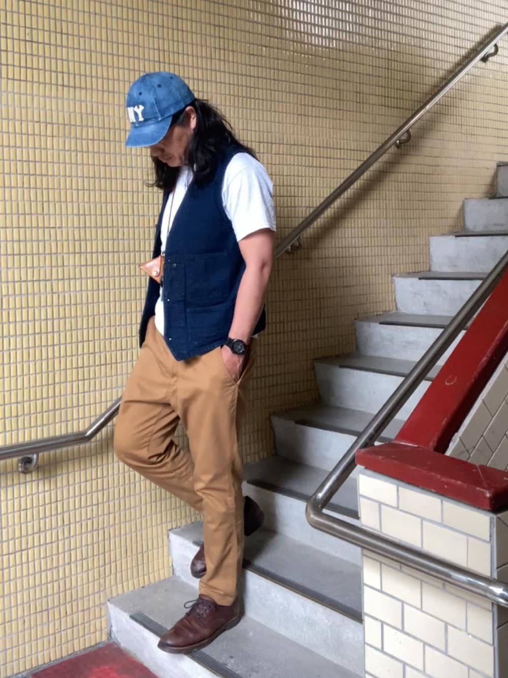 ブラウン系のチノパンツ、ブルー系のベスト、ブラウン系のその他シューズを着用したメンズの春コーディネートの2枚目の写真