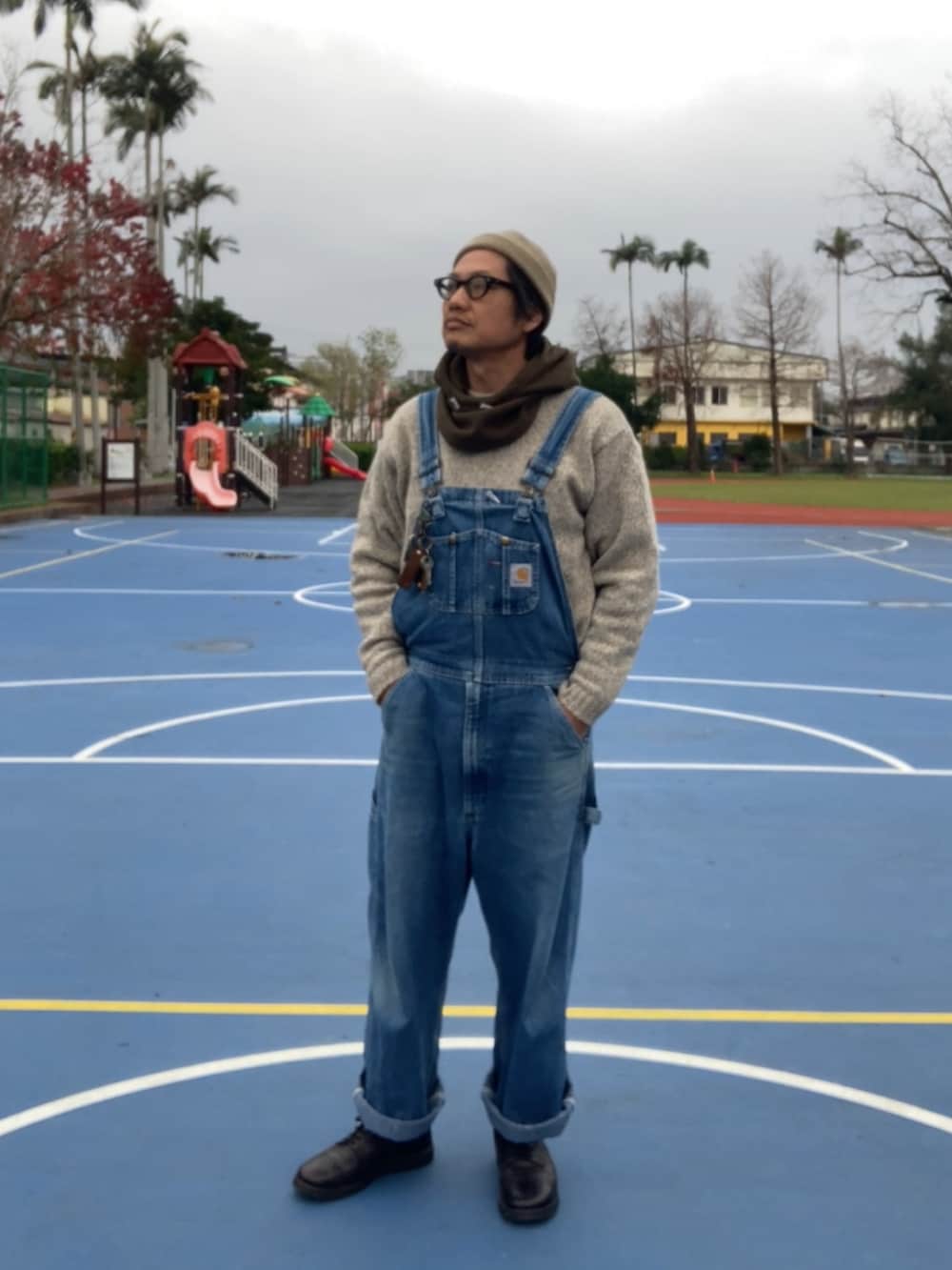 ベージュ系のニット/セーター、ブルー系のサロペット/オーバーオール、ブラック系のシューズを着用したメンズの冬コーディネートの3枚目の写真