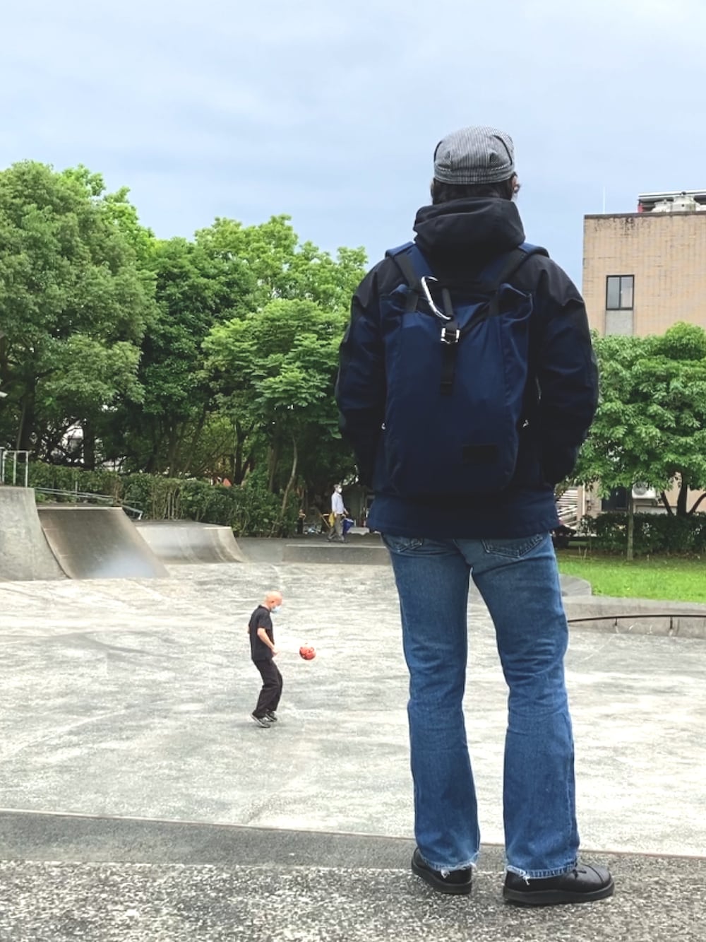 ブラック系のマウンテンパーカー、ブルー系のバックパック/リュック、ブラック系のシューズを着用したメンズの春コーディネートの2枚目の写真