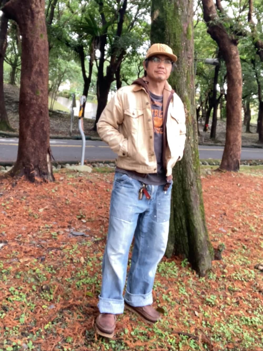 ベージュ系のデニムジャケット、ブラウン系のパーカー、ブルー系のデニムパンツを着用したメンズの冬コーディネートの2枚目の写真