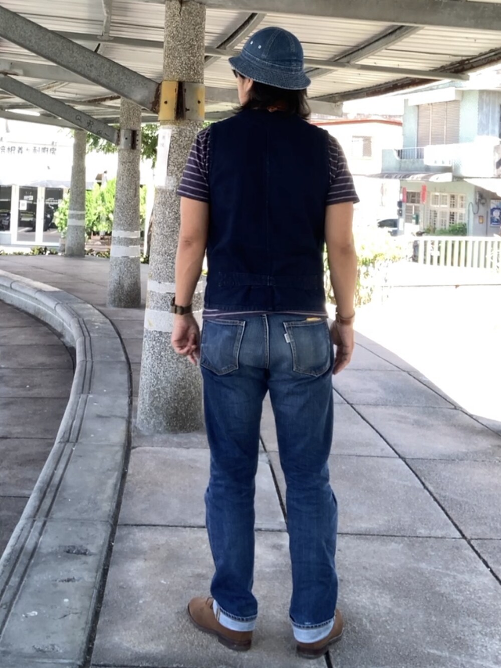 ブルー系のベスト、ブラウン系のブーツ、ブルー系のTシャツ/カットソーを着用したメンズの秋コーディネートの2枚目の写真