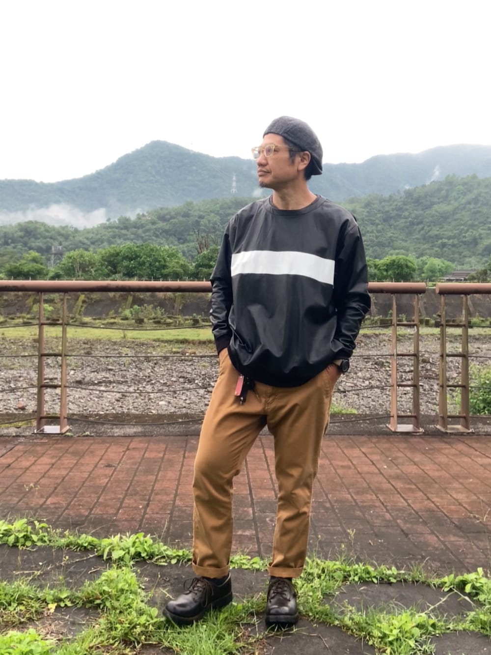 ブラック系のその他トップス、ブラウン系のチノパンツ、ブラック系のブーツを着用したメンズの春コーディネートの2枚目の写真