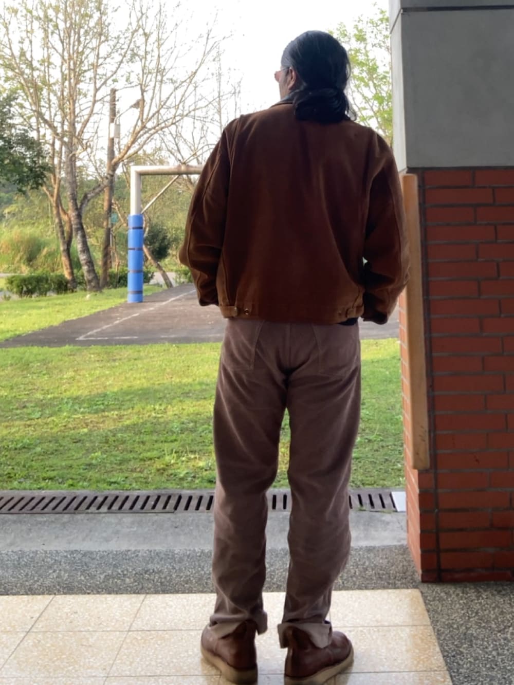 ブラウン系のその他アウター、ブラウン系のスリッポン、ブラック系のTシャツ/カットソーを着用したメンズの春コーディネートの2枚目の写真