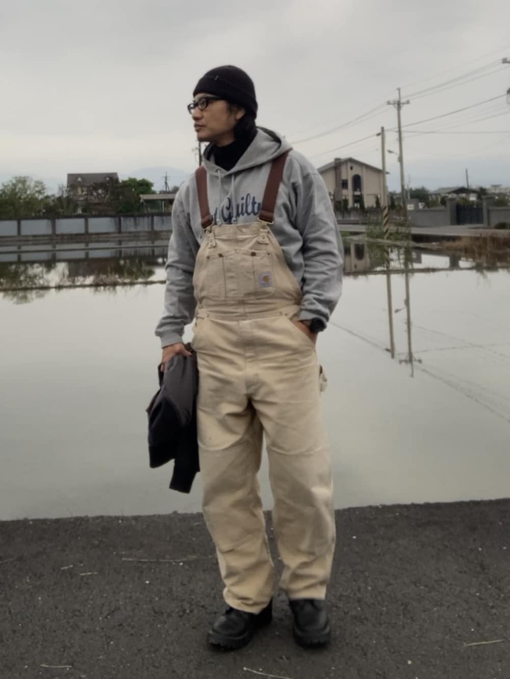 ブラック系のMA-1、ブラウン系のサロペット/オーバーオール、ブラック系のブーツを着用したメンズの冬コーディネートの3枚目の写真