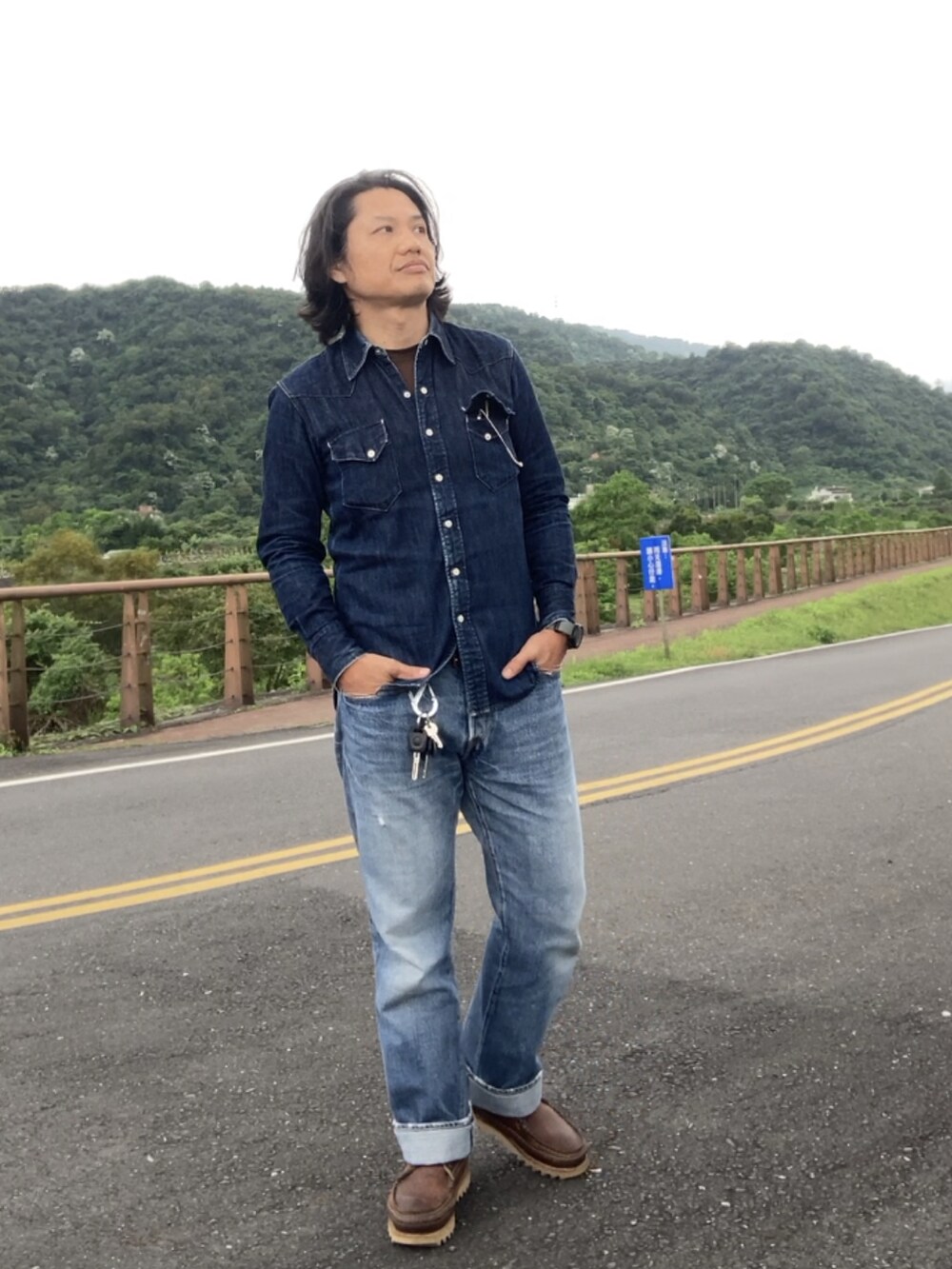 ブルー系のデニムパンツ、ブラウン系のブーツ、ブルー系のシャツ/ブラウスを着用したメンズの春コーディネートの2枚目の写真