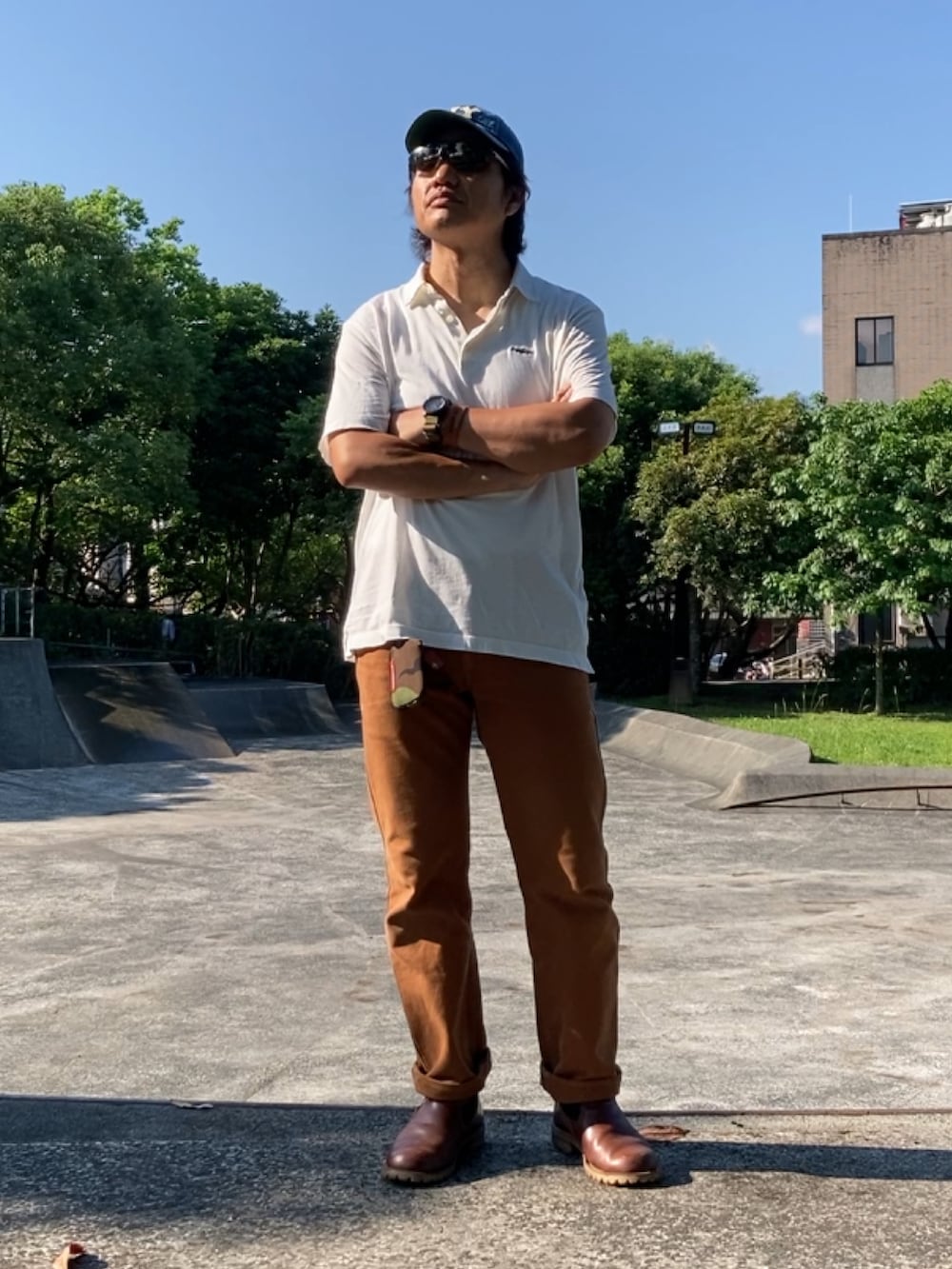 ブルー系のシャツ/ブラウス、ブラウン系のチノパンツ、ブラウン系のスリッポンを着用したメンズの春コーディネートの2枚目の写真