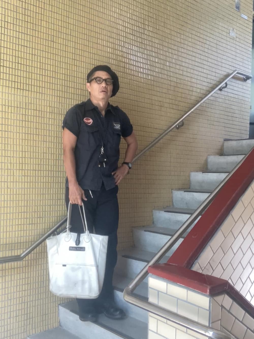 ホワイト系のトートバッグ、ブラック系のシャツ/ブラウス、ブラック系のチノパンツを着用したメンズの秋コーディネートの3枚目の写真