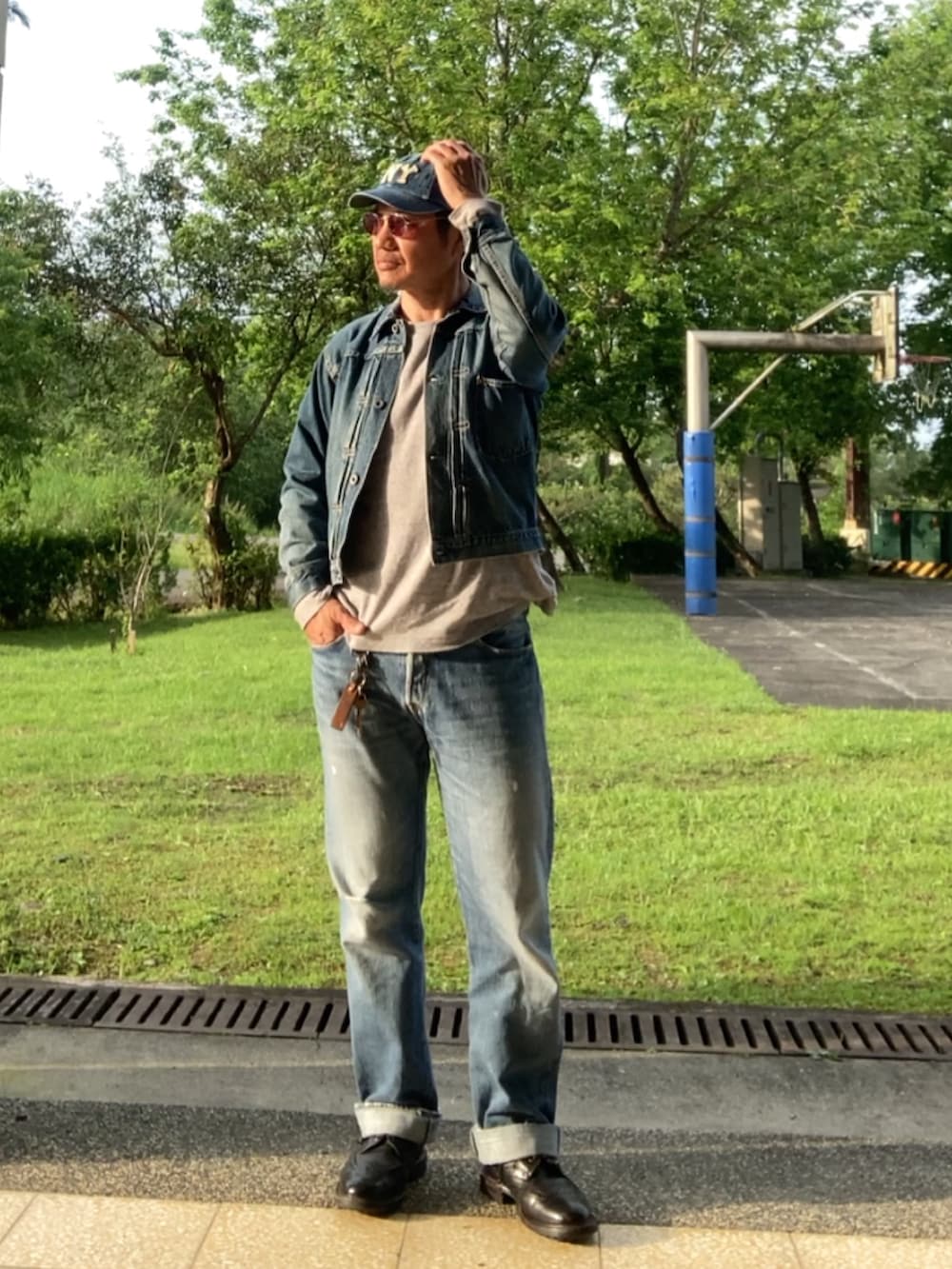 ブルー系のデニムジャケット、ブルー系のデニムパンツ、ブラウン系のTシャツ/カットソーを着用したメンズの春コーディネートの2枚目の写真