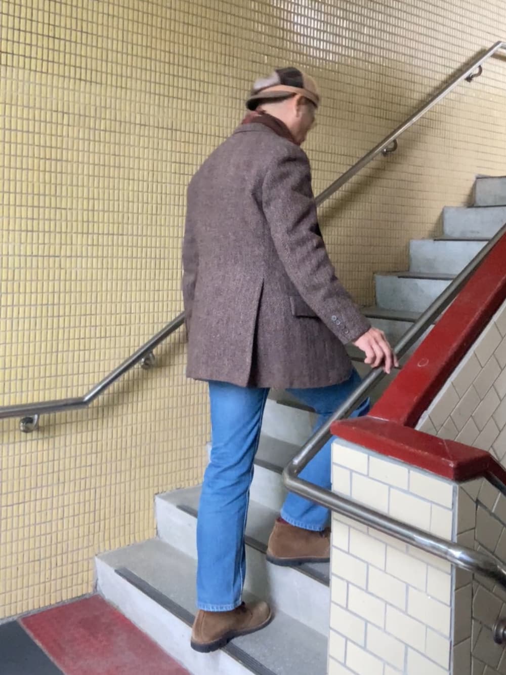 ブラウン系のテーラードジャケット、ブラウン系のニット/セーター、ブルー系のデニムパンツを着用したメンズの冬コーディネートの3枚目の写真