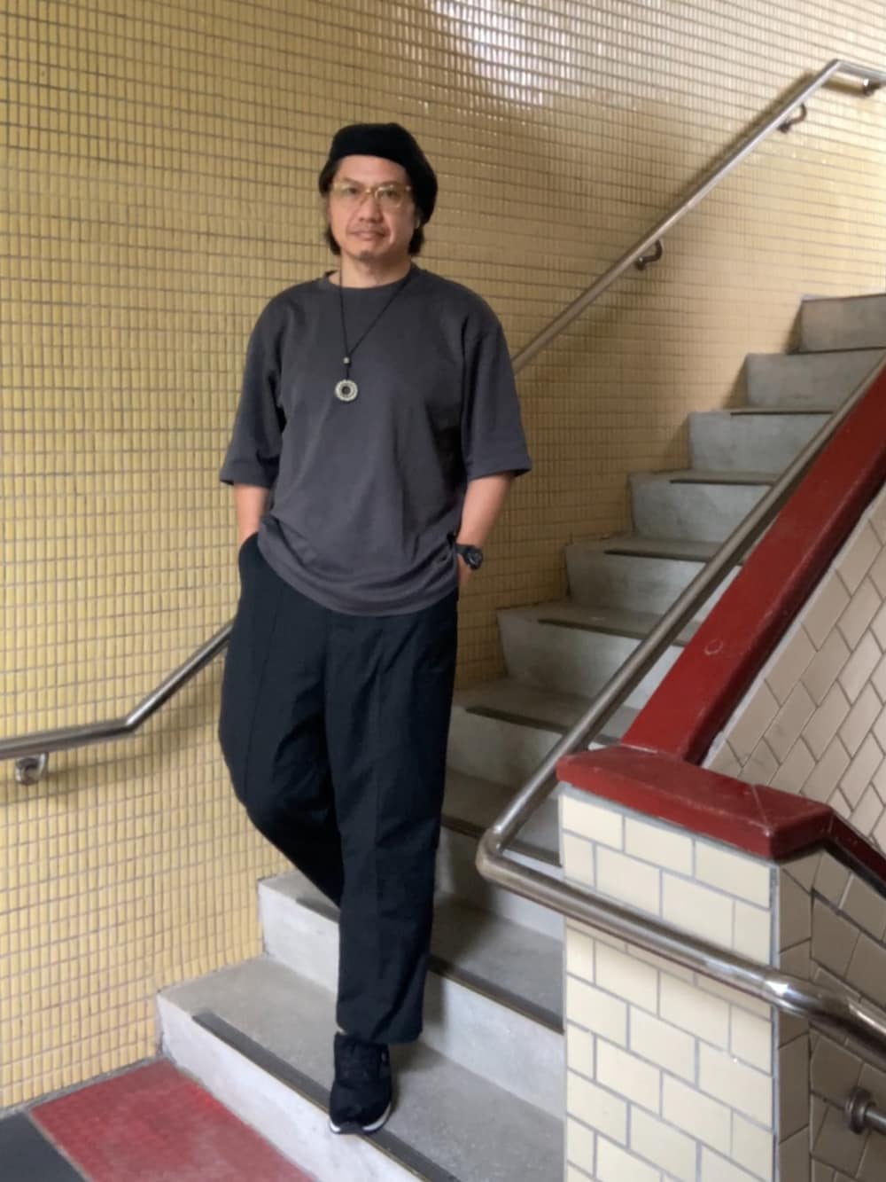 グレー系のTシャツ/カットソー、ブラック系のスラックス、ブラック系のスニーカーを着用したメンズの春コーディネートの2枚目の写真