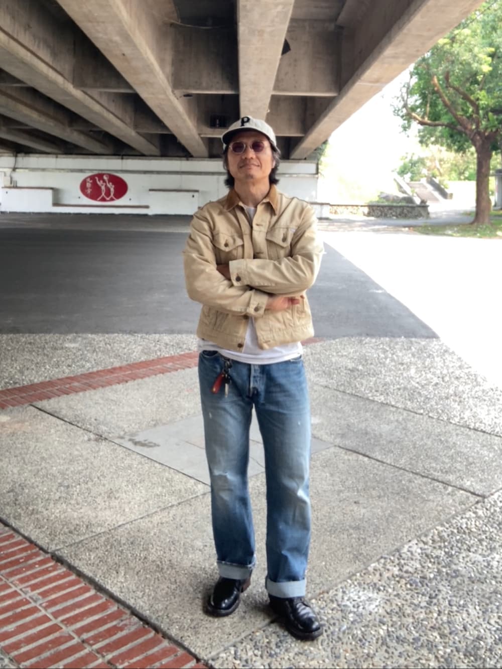 グレー系のTシャツ/カットソー、ベージュ系のデニムジャケット、ブルー系のデニムパンツを着用したメンズの春コーディネートの3枚目の写真
