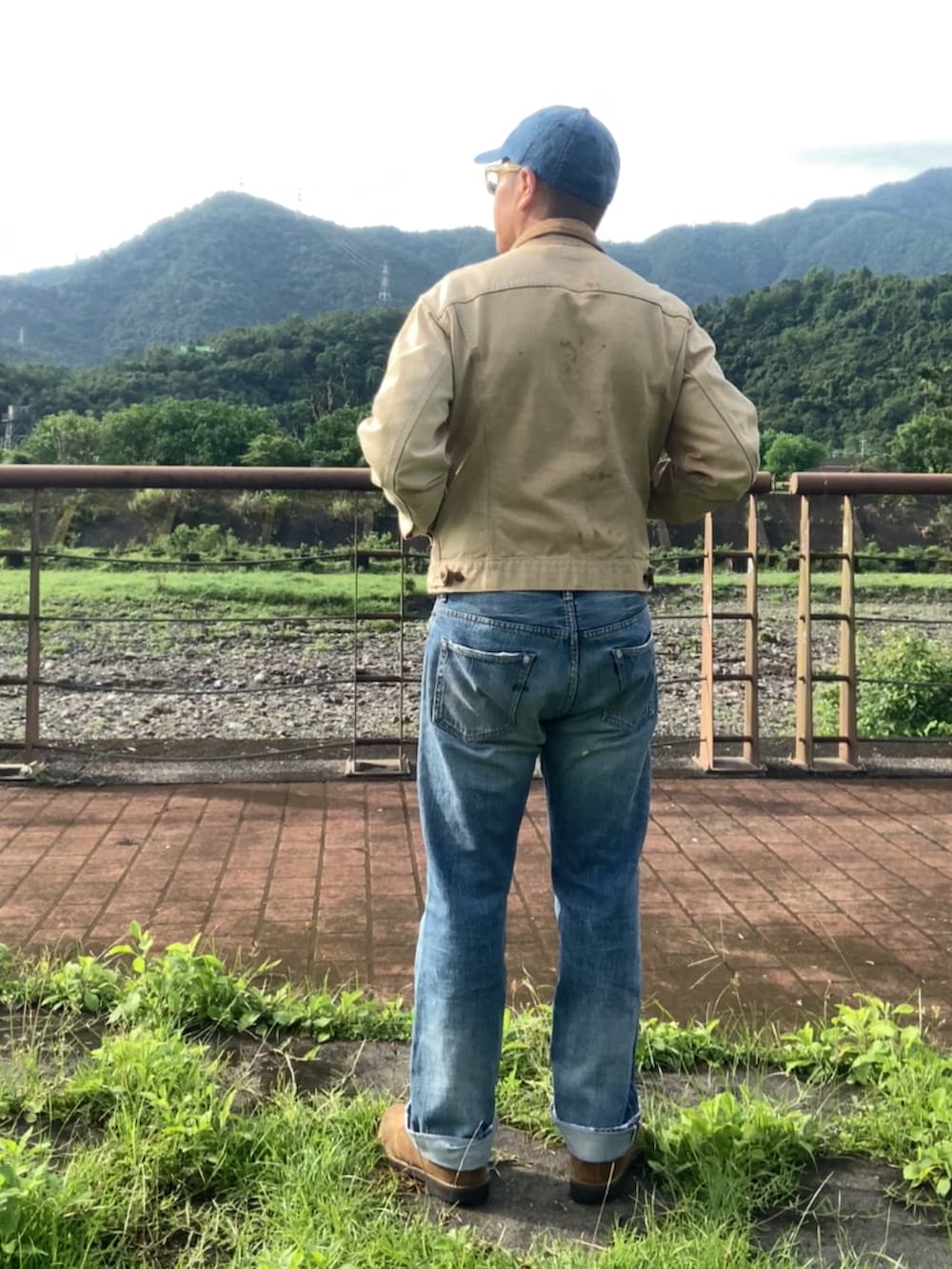 ベージュ系のデニムジャケット、ブルー系のデニムパンツ、ブラウン系のブーツを着用したメンズの春コーディネートの3枚目の写真