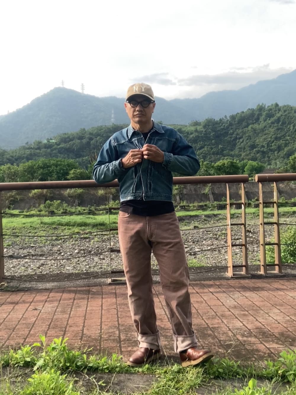 ブルー系のデニムジャケット、ブラック系のTシャツ/カットソー、ブラウン系のその他パンツを着用したメンズの春コーディネートの2枚目の写真