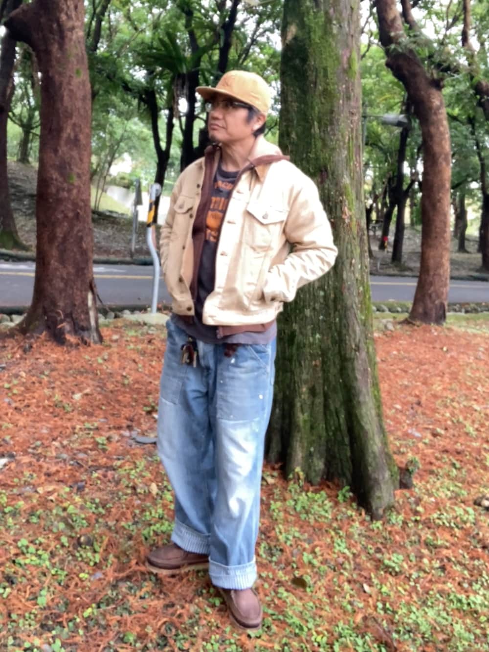 ベージュ系のデニムジャケット、ブラウン系のパーカー、ブルー系のデニムパンツを着用したメンズの冬コーディネートの3枚目の写真