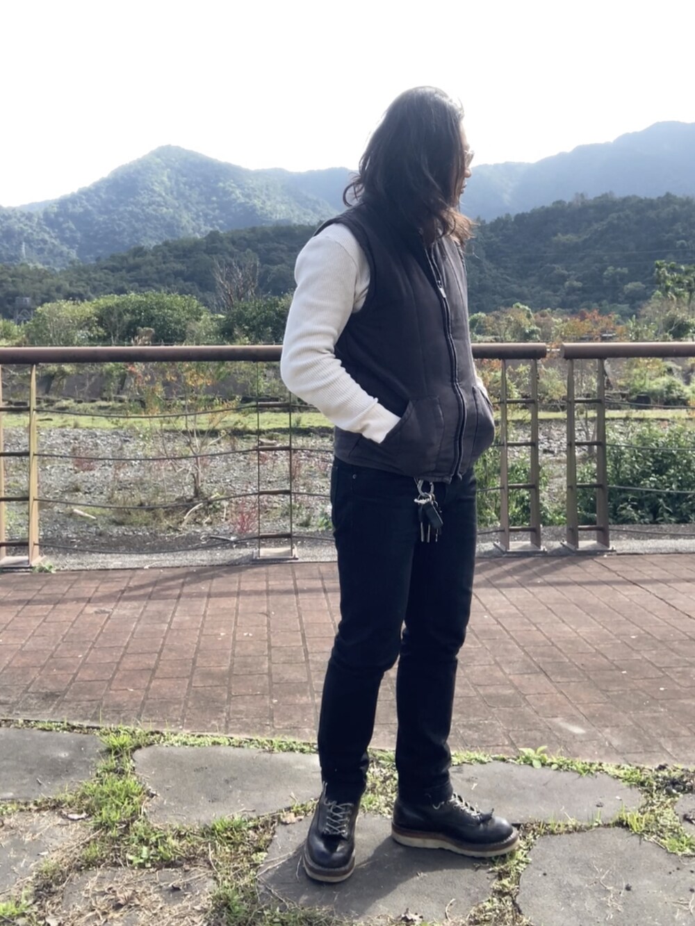 ブラック系のその他アウター、ブラック系のブーツ、ベージュ系のTシャツ/カットソーを着用したメンズの冬コーディネートの4枚目の写真