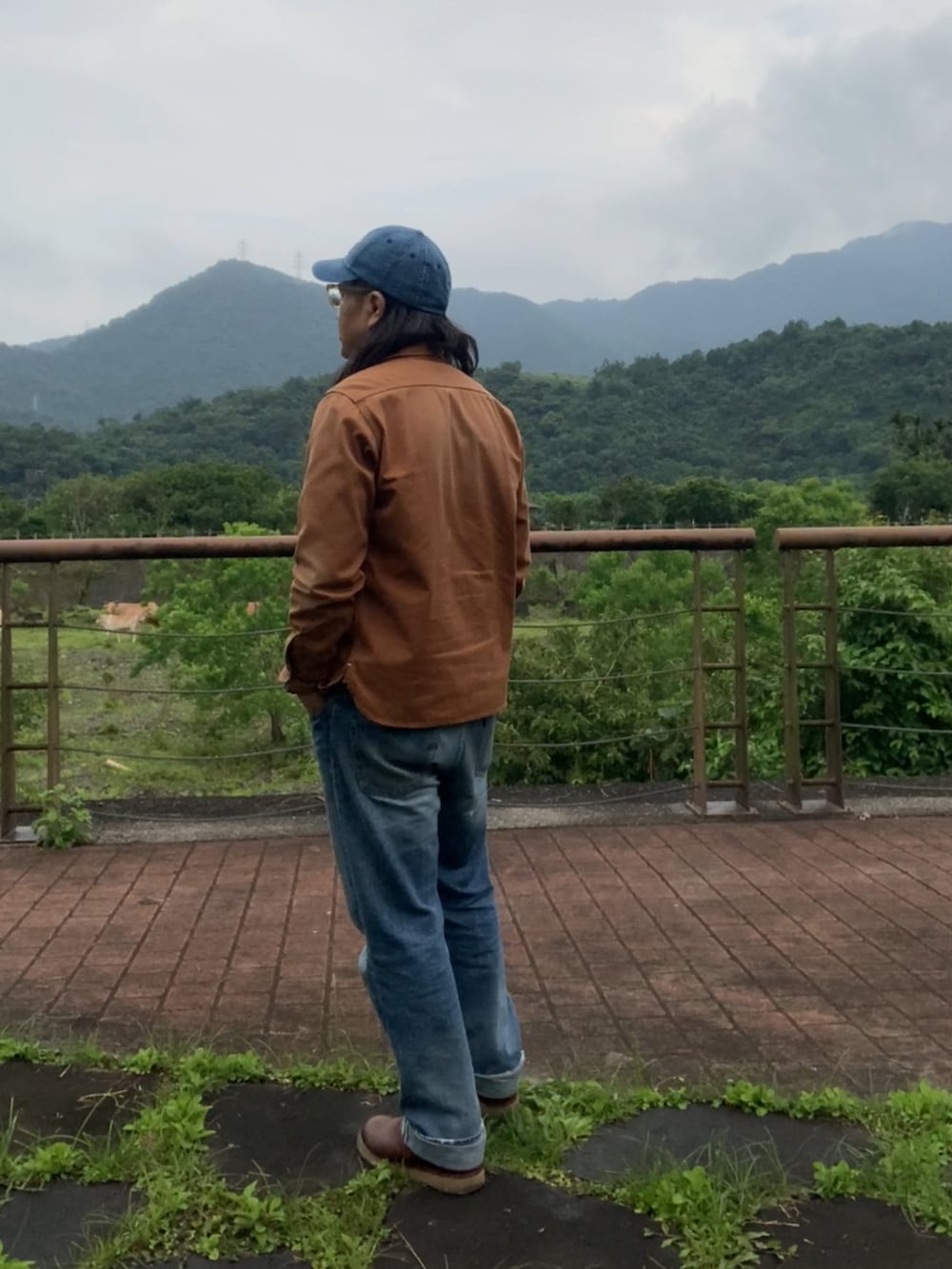 ブラウン系のシャツ/ブラウス、ブラウン系のスリッポン、ブルー系のデニムパンツを着用したメンズの春コーディネートの2枚目の写真