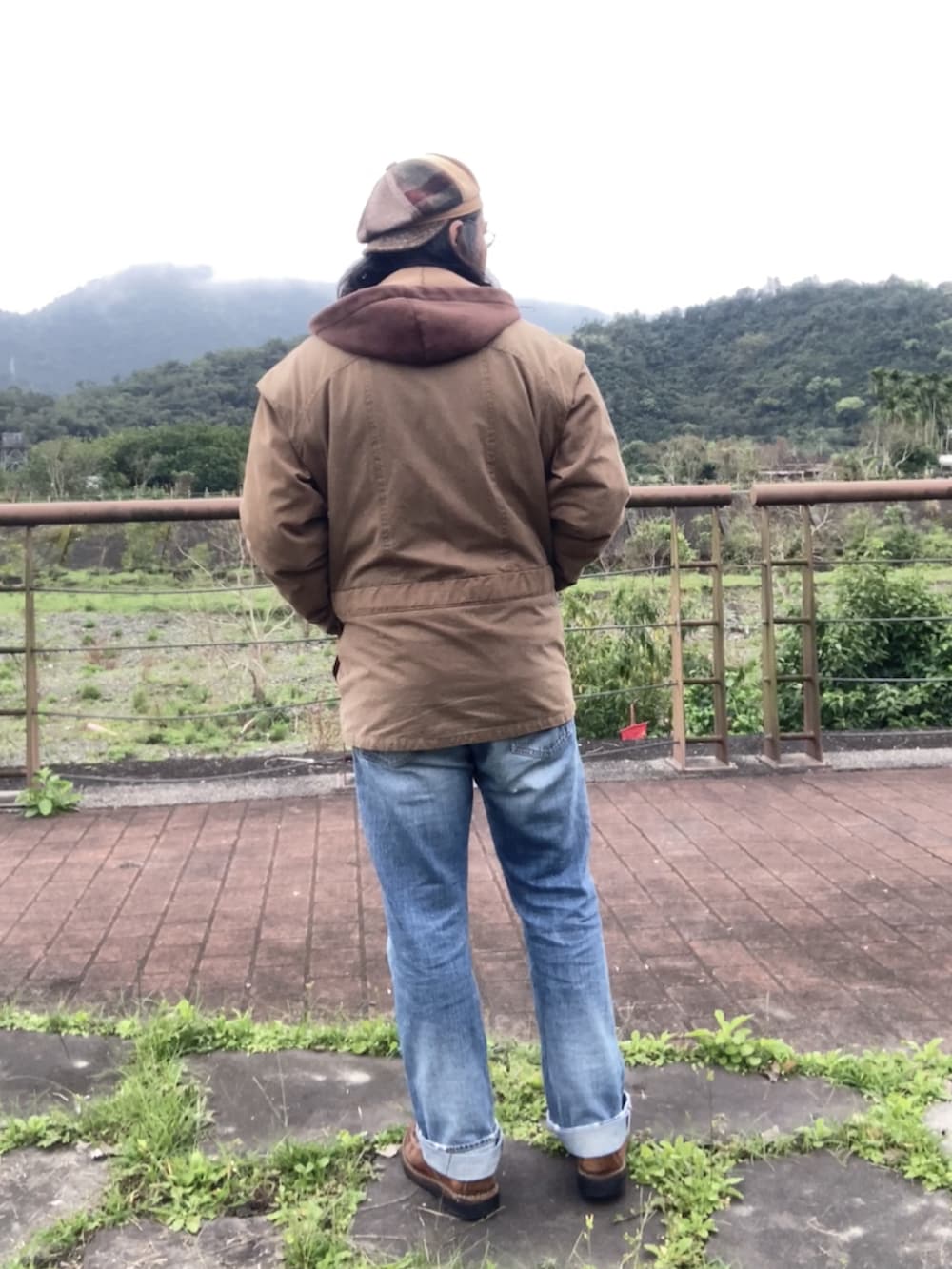 ブラウン系のパーカー、ブルー系のデニムパンツ、ブラウン系のブーツを着用したメンズの冬コーディネートの2枚目の写真