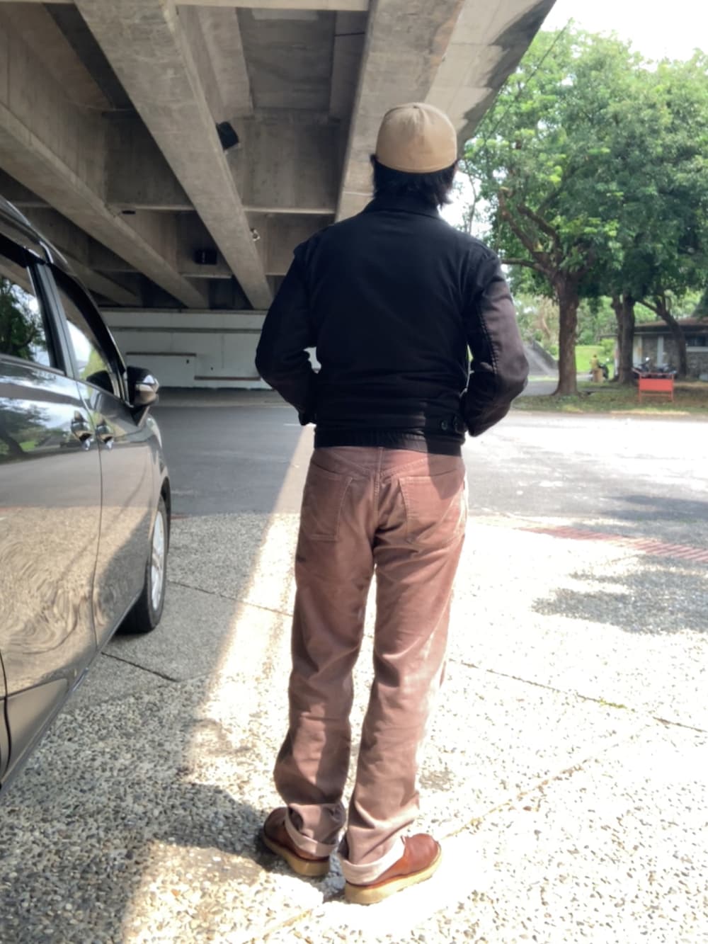 ブラック系のTシャツ/カットソー、ブラック系のブルゾン、ブラウン系のその他パンツを着用したメンズの春コーディネートの3枚目の写真