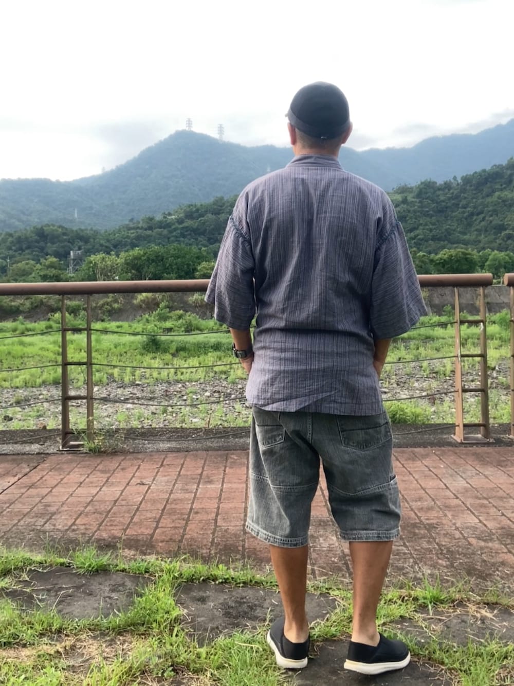 ブラック系のスリッポン、グレー系のその他トップス、グレー系のTシャツ/カットソーを着用したメンズの夏コーディネートの3枚目の写真