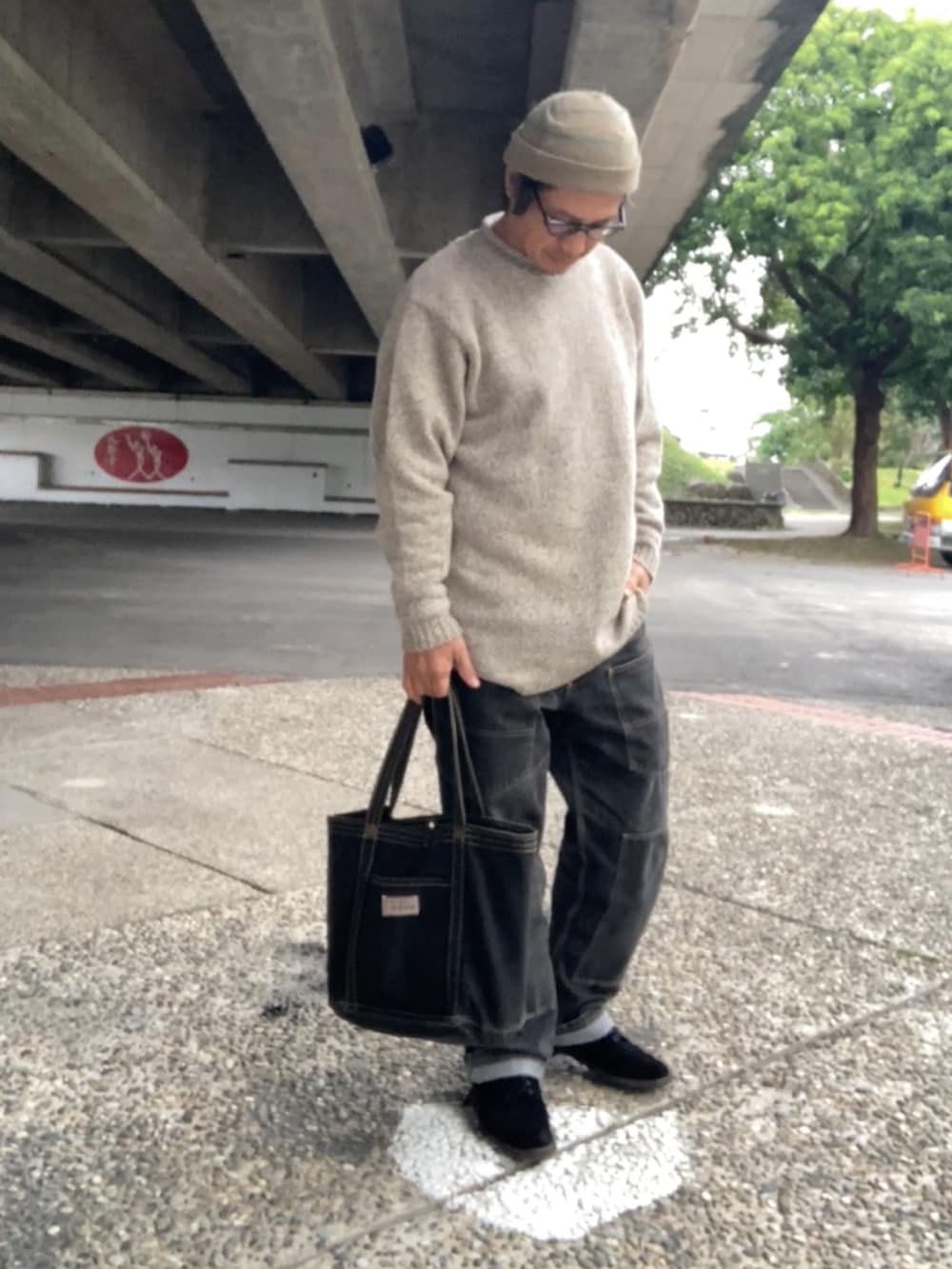 ベージュ系のニット/セーター、ブラウン系のTシャツ/カットソー、ブラック系のデニムパンツを着用したメンズの冬コーディネートの2枚目の写真