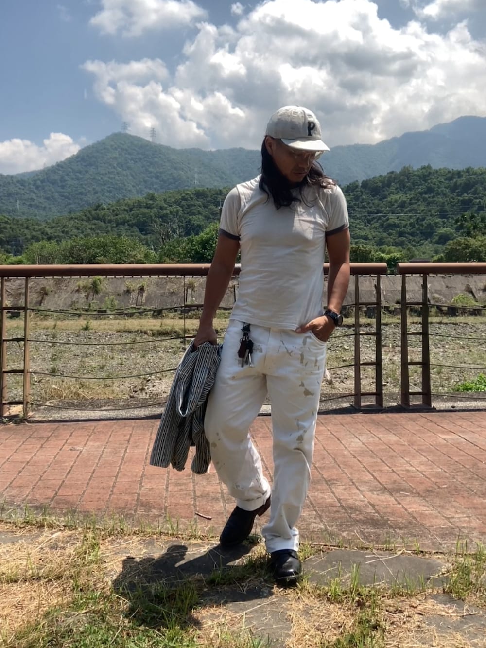 ブラック系のブーツ、ベージュ系のカバーオール、グレー系のTシャツ/カットソーを着用したメンズの夏コーディネートの4枚目の写真