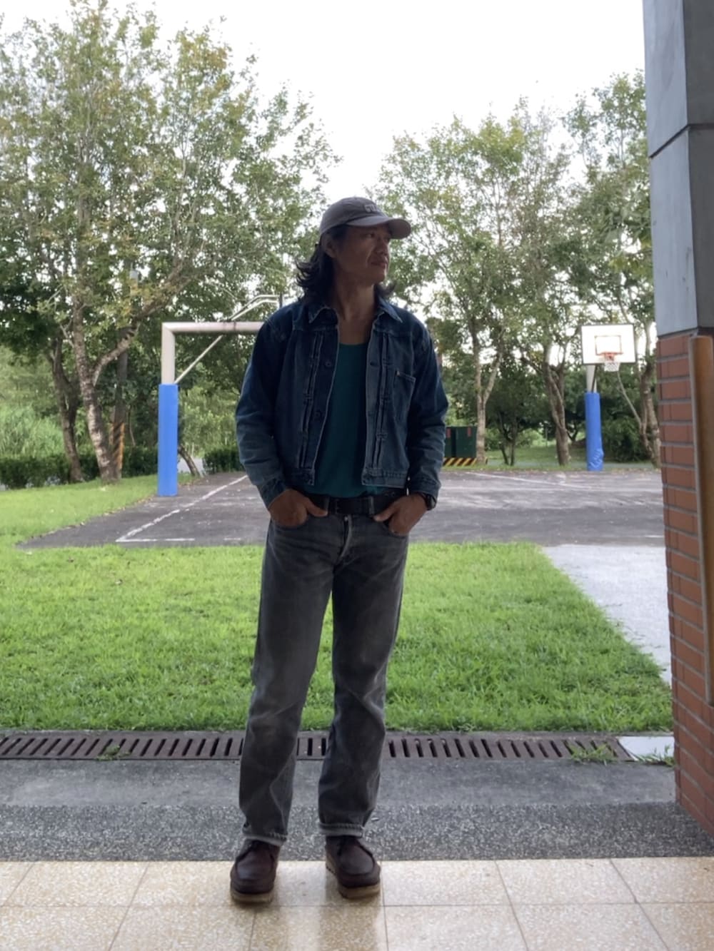 ブルー系のデニムジャケット、ブラック系のデニムパンツ、ブラウン系のブーツを着用したメンズの秋コーディネートの3枚目の写真