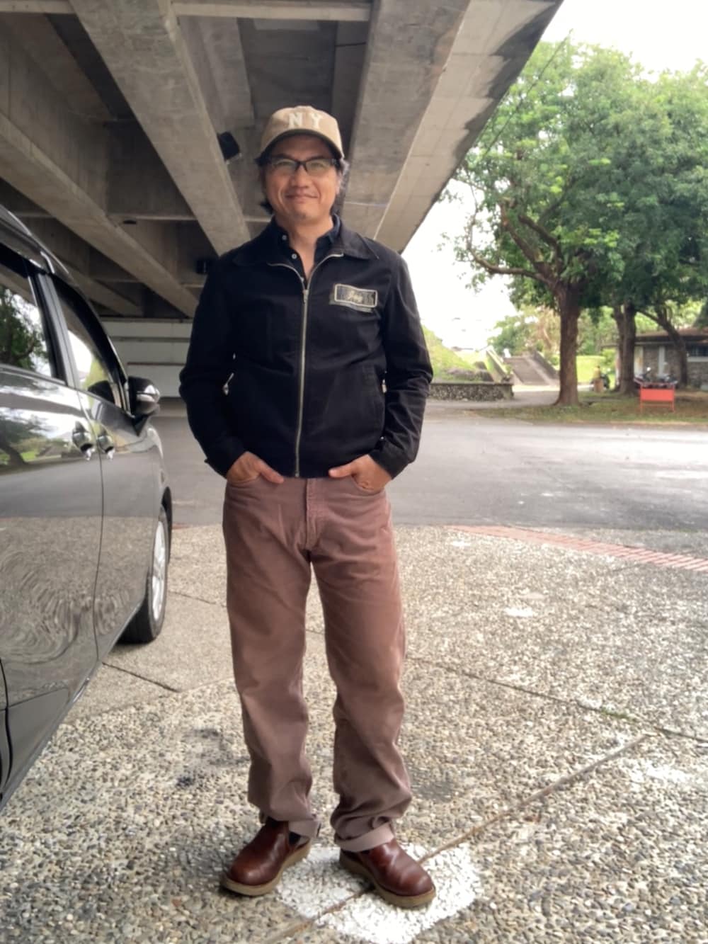 ブラック系のTシャツ/カットソー、ブラック系のブルゾン、ブラウン系のその他パンツを着用したメンズの春コーディネートの4枚目の写真