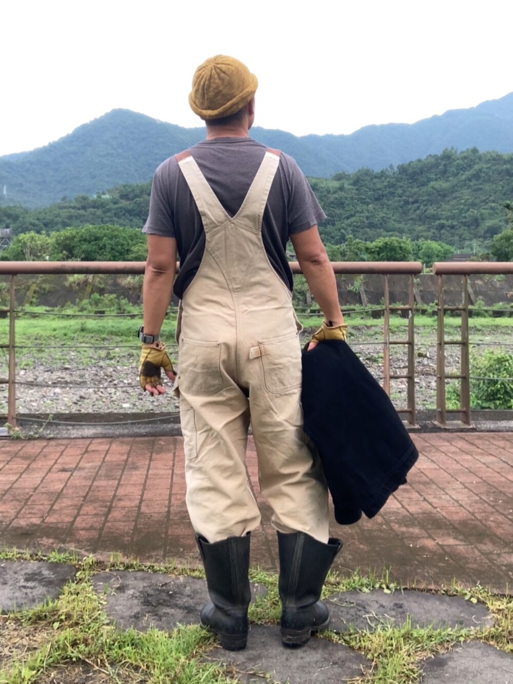 ブラック系のTシャツ/カットソー、ブラウン系のサロペット/オーバーオール、ブラック系のカバーオールを着用したメンズの春コーディネートの3枚目の写真