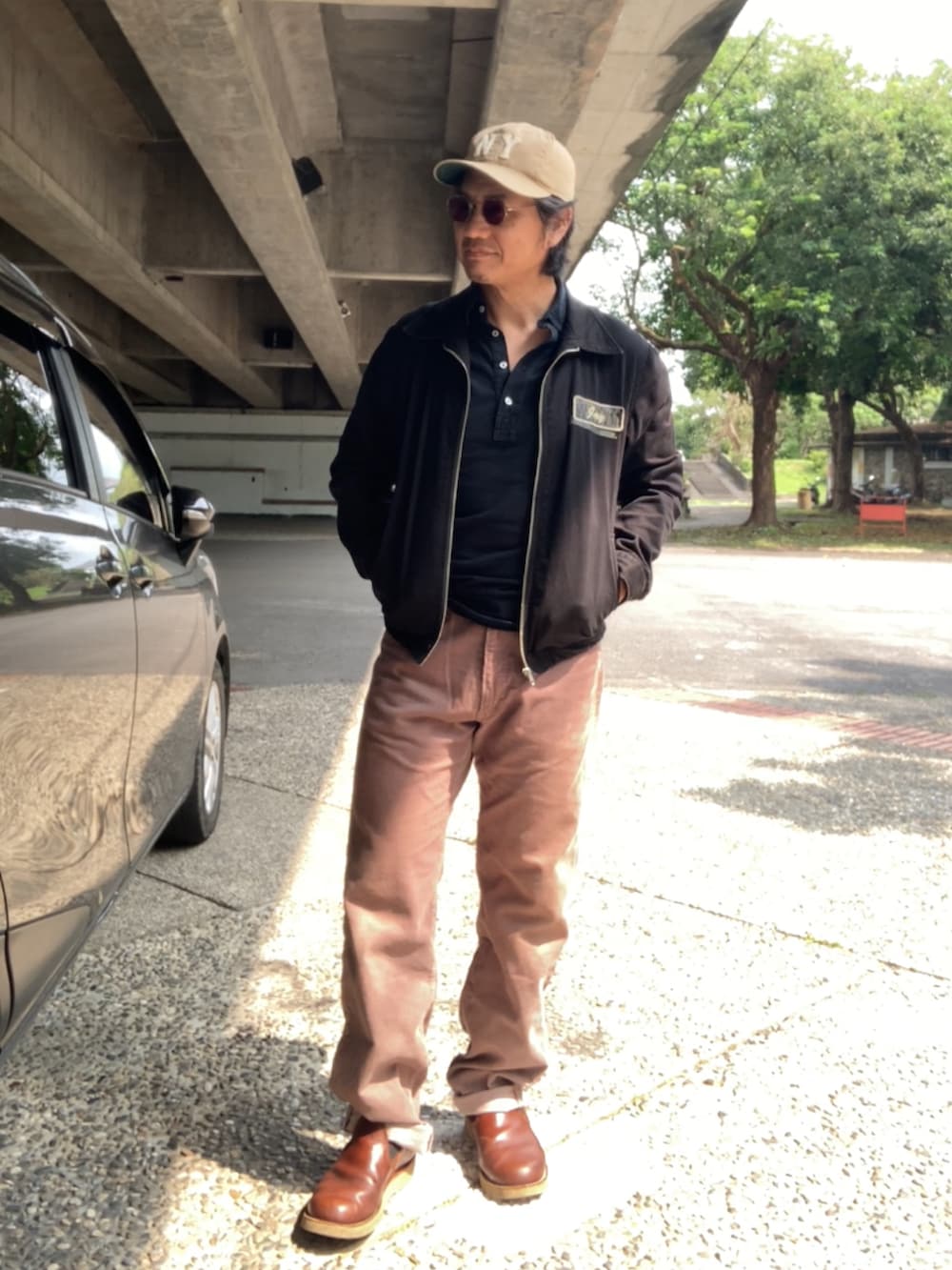 ブラック系のTシャツ/カットソー、ブラック系のブルゾン、ブラウン系のその他パンツを着用したメンズの春コーディネートの2枚目の写真