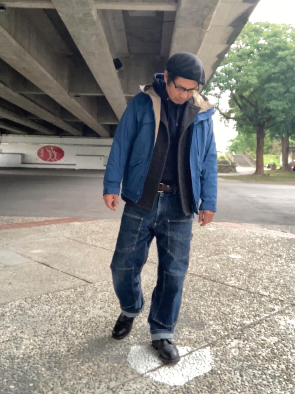 ブルー系のパーカー、グレー系のピーコート、ブルー系のマウンテンパーカーを着用したメンズの冬コーディネートの2枚目の写真