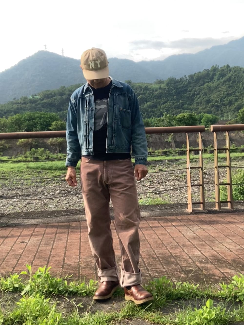 ブルー系のデニムジャケット、ブラック系のTシャツ/カットソー、ブラウン系のその他パンツを着用したメンズの春コーディネートの3枚目の写真