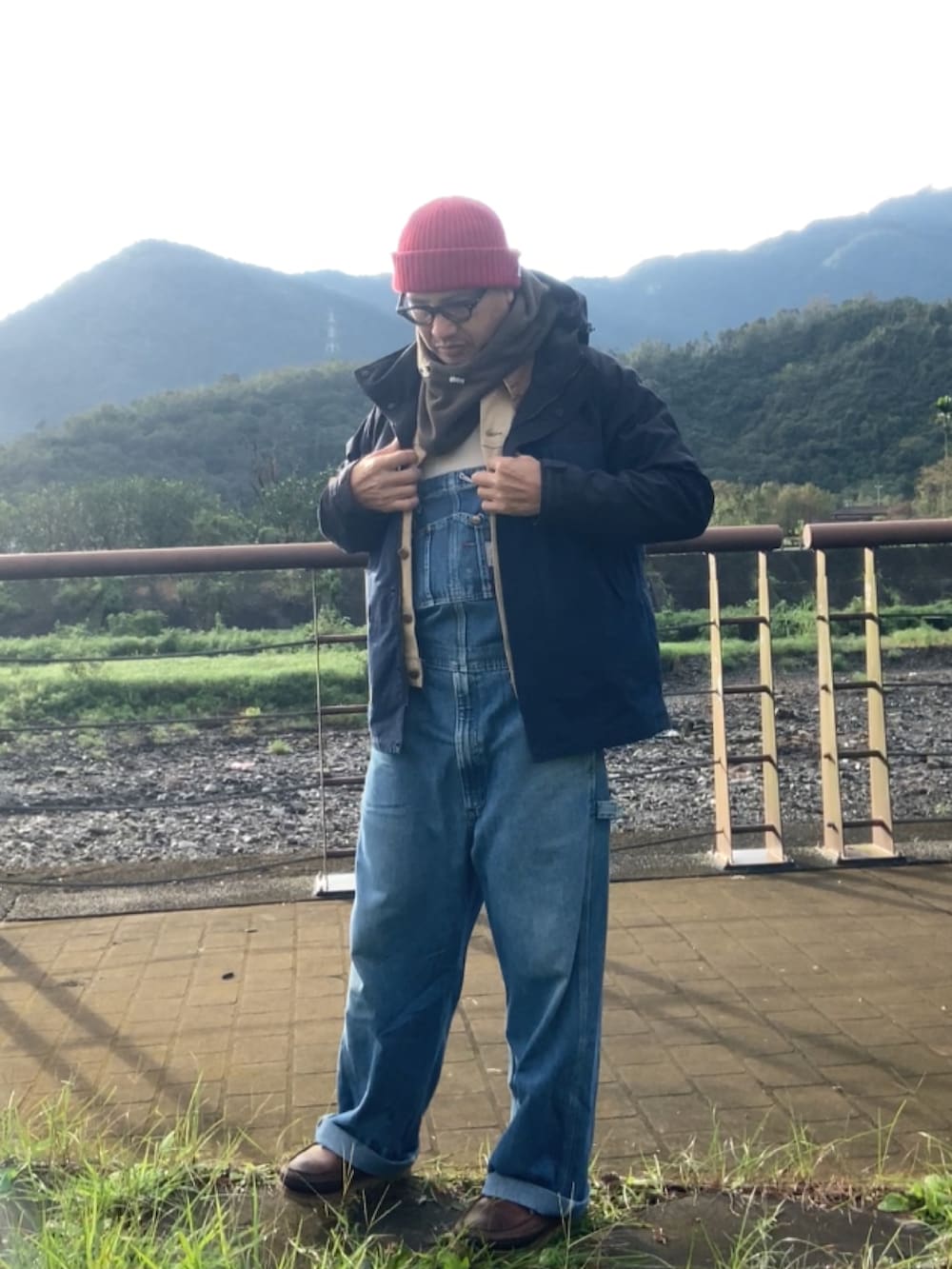 ベージュ系のデニムジャケット、ブルー系のサロペット/オーバーオール、ブラウン系のブーツを着用したメンズの冬コーディネートの2枚目の写真