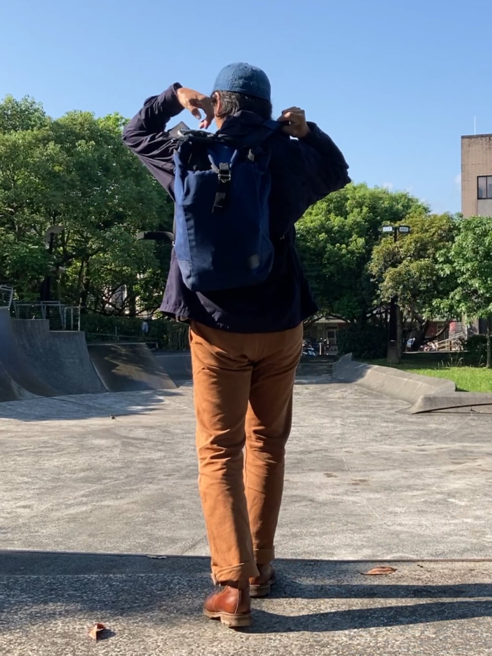 ブルー系のシャツ/ブラウス、ブラウン系のチノパンツ、ブラウン系のスリッポンを着用したメンズの春コーディネートの3枚目の写真