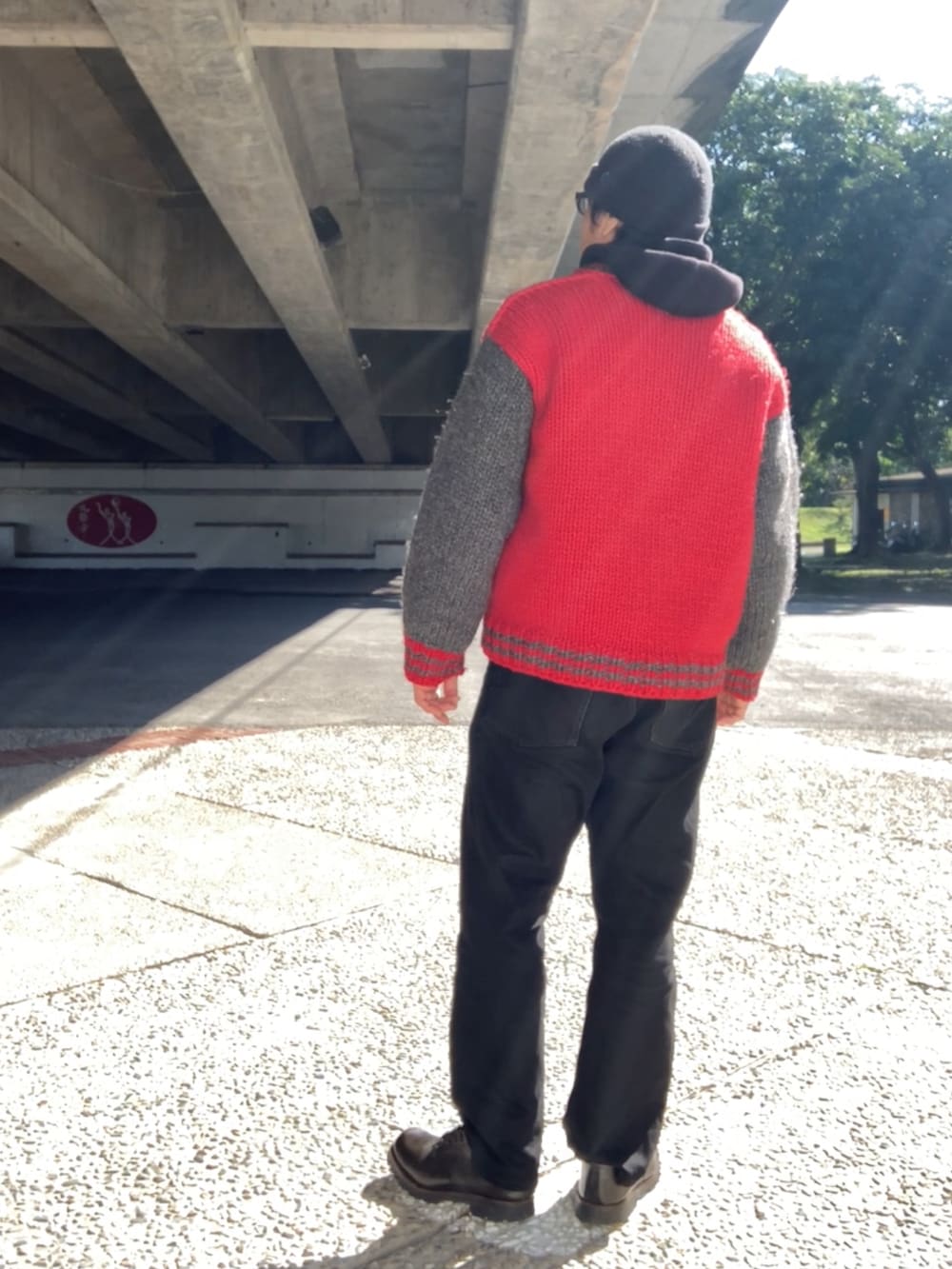 レッド系のジャケット/アウター、ブラック系のパーカー、ブラック系のデニムパンツを着用したメンズの冬コーディネートの3枚目の写真